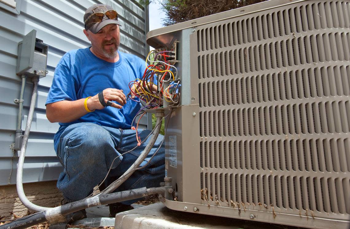 Jerry Cline of Total Heating and Cooling works on a air conditioner unit in 2011.