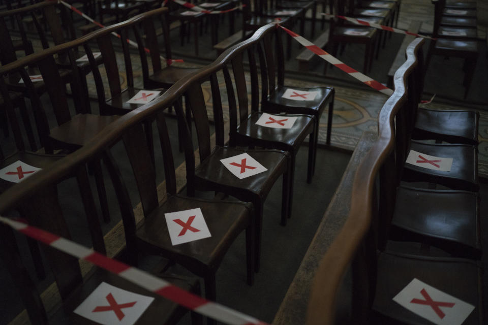 Chruch seats are marked to indicate the appropriate social distancing measures at the St. Vincent de Paul church in Marseille, southern France, Sunday, March 22, 2020. As mass gatherings are forbidden due to measures to prevent the spread of COVID- 19, priests are using technology to reach worshippers forced to stay at home. For most people, the new coronavirus causes only mild or moderate symptoms. (AP Photo/Daniel Cole)