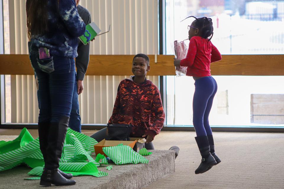 Lawrence Charma is happy to receive new snow boots as his younger sister, Gloria, jumps up and down with joy at her new pink lunch bag on Tuesday, Nov. 29.