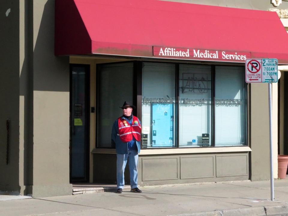 A volunteer escort outside Affiliated Medical Services, a Milwaukee abortion clinic