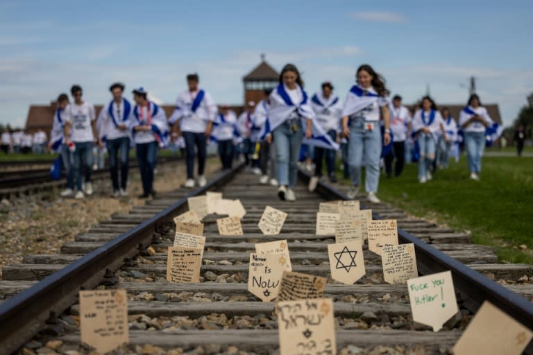 Placas de madera con mensajes y oraciones colocadas en la vía férrea que conduce al antiguo campo de exterminio nazi de Auschwitz-Birkenau, en Polonia, el 6 de mayo de 2024 (Wojtek Radwanski)