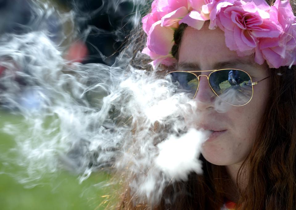 A woman smokes marijuana during the 4/20 Rally at the Civic Center in Denver, Colorado, April 20, 2014. Thousands of marijuana enthusiasts gathered in Colorado and Washington state over the weekend for an annual celebration of cannabis culture with rallies, concerts and trade shows in the first two states to legalize recreational marijuana. REUTERS/Mark Leffingwell (UNITED STATES - Tags: SOCIETY POLITICS DRUGS)