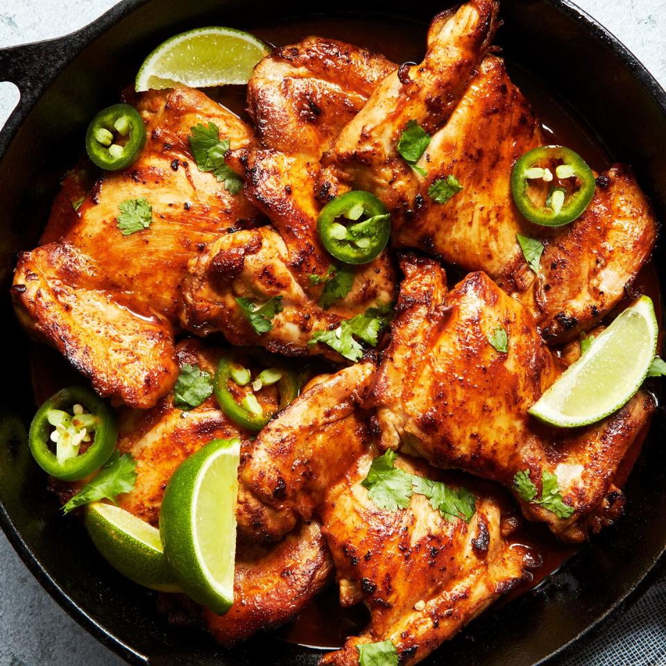 baked chicken thighs with lime wedges and jalapeno slices