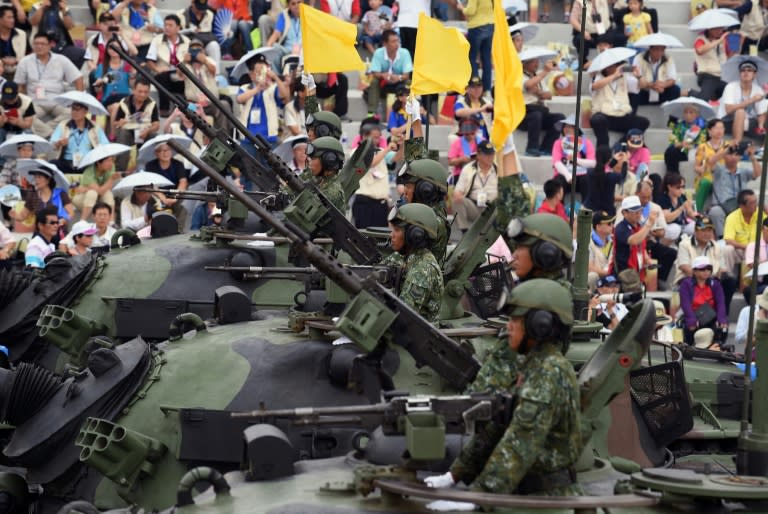 Soldiers salute from the M60A3 tanks during the 70th Anniversary of the WWII at the Huko military in northern Hsinchu, Taiwan on July 4, 2015