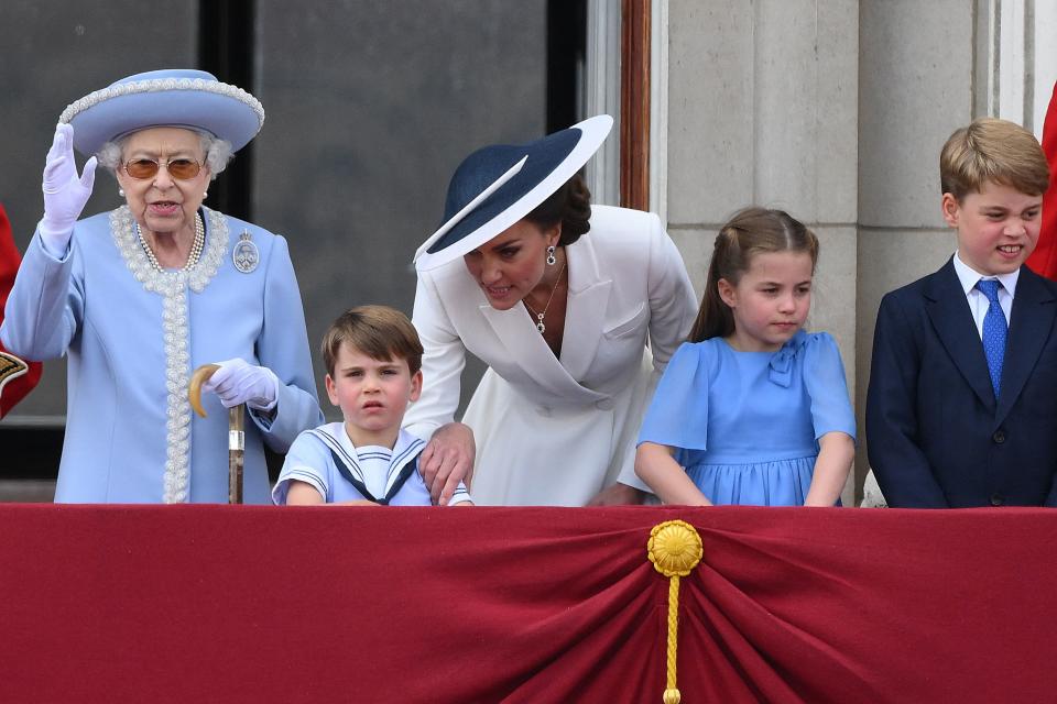 The Queen waves to the crowds alongside her great-grandchildren Prince Louise, Princess Charlotte and Prince George, with their mother the Duchess of Cambridge. (PA)