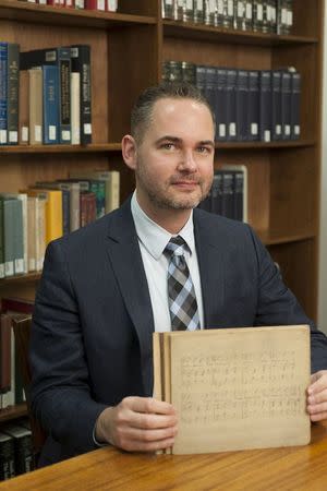 Library director James Procell poses with sheet music for the song Good Morning To All in an undated photo provided by the University of Louisville, Kentucky. REUTERS/University of Louisville/Handout via Reuters