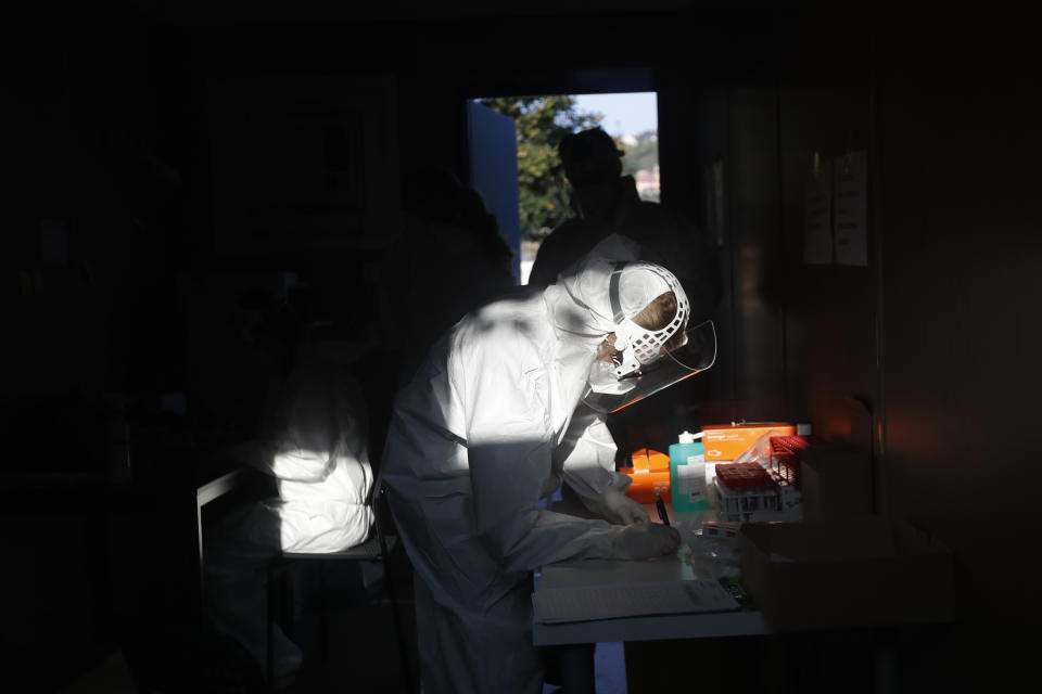 A healthcare worker at a sampling station for COVID-19 in Prague, Czech Republic, Monday, Sept. 21, 2020. The country coped well with the first wave of the coronavirus infections in the spring but has been facing a record surge of the new confirmed cases last week. (AP Photo/Petr David Josek)