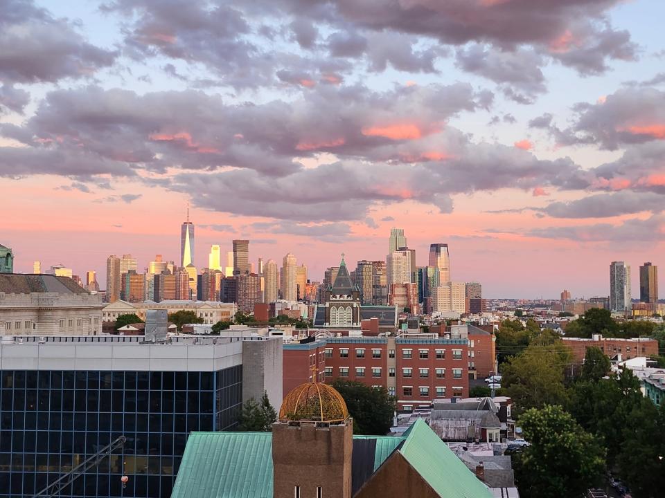 <p>A picture taken with the Galaxy Z Flip 4 showing a closer view of a cityscape at sunset with pink and blue hues in the sky. The scene is zoomed in on distant Manhattan buildings.</p>
