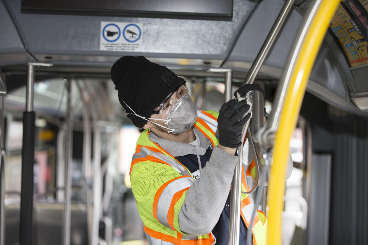 A utility service worker deep cleans a bus in Seattle, Wash., in early March. Here's how to know what precautions your state may be taking to keep you safe. (Photo: Karen Ducey/Getty Images)