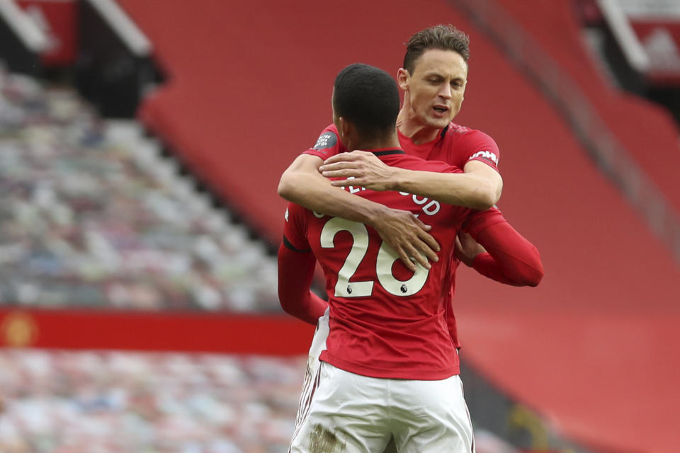 Manchester United's Mason Greenwood (30) celebrates after scoring his side's opening goal with Manchester United's Nemanja Matic during the English Premier League soccer match between Manchester United and West Ham at the Old Trafford stadium in Manchester, England, Wednesday, July 22, 2020. (Cath Ivill/Pool via AP)