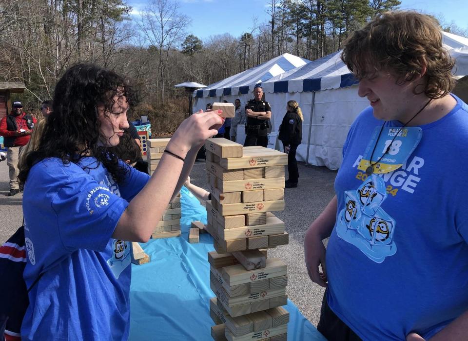 On the left, Kayla Swope plays Jenga with Landon Young at 2024 Richmond Polar Plunge at Pocahontas State Park.