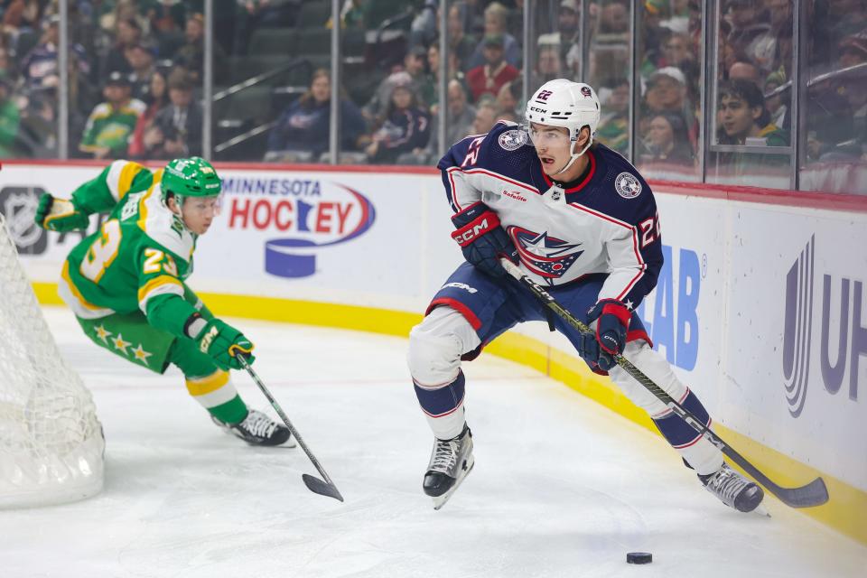 Oct 21, 2023; Saint Paul, Minnesota, USA; Columbus Blue Jackets defenseman Jake Bean (22) skates with the puck alongside Minnesota Wild center Marco Rossi (23) during the first period at Xcel Energy Center. Mandatory Credit: Matt Krohn-USA TODAY Sports