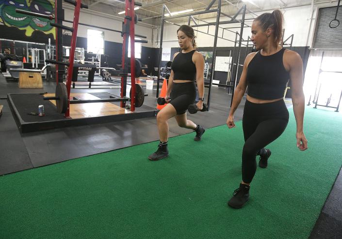 Megan Ayers, right, conducts a training session with Caroline Hong on Wednesday at FitCo Gym in North Canton. The gym is hosting a Lift-a-thon charity event Aug. 20 to help raise money for St. Jude Children's Research Hospital.