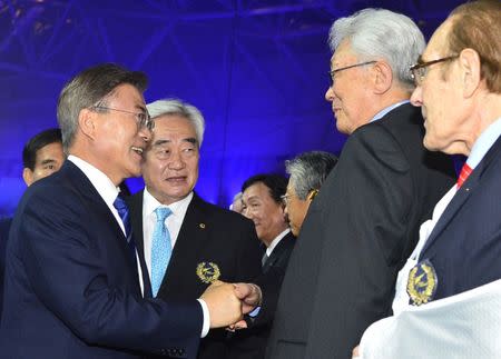 South Korean President Moon Jae-in shakes hands with Chang Ung, North Korea's International Olympic Committee (IOC) member, during an opening ceremony of 2017 WTF World Taekwondo Championships in Muju, South Korea June 24, 2017. Picture taken on June 24, 2017. Kim Joo-hyung/Yonhap via REUTERS