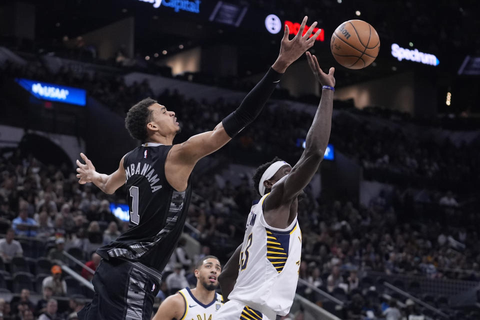 San Antonio Spurs center Victor Wembanyama (1) and Indiana Pacers forward Pascal Siakam, right, reach for a rebound during the first half of an NBA basketball game in San Antonio, Sunday, March 3, 2024. (AP Photo/Eric Gay)