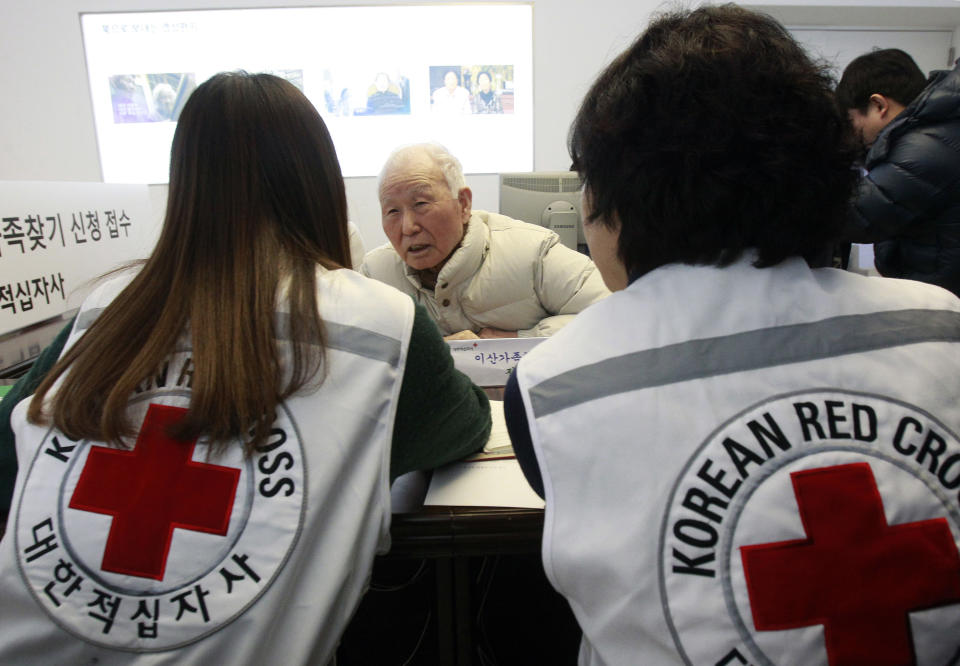 South Korean Lee Kyun-myoung, 93, center, talks with Red Cross members as he fills out application forms to reunite with his family members living in North Korea, at the Korea Red Cross headquarters in Seoul, South Korea, Thursday, Feb. 6, 2014. The rival Koreas agreed Wednesday to hold their first reunions of Korean War-divided families in more than three years later this month, another small step forward in easing tensions that comes despite North Korea's anger over upcoming U.S.-South Korean military drills. (AP Photo/Ahn Young-joon)