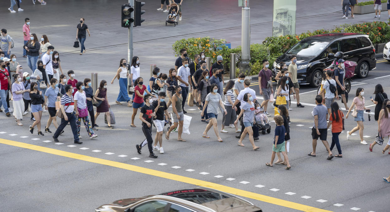 A pedestrian crowd crossing traffic light in Singapore.