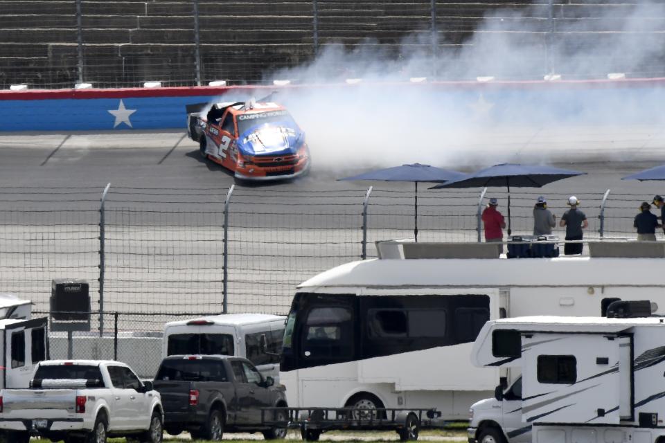 Fans look on as Sheldon Creed crashes in Turn 2 during a NASCAR Truck Series auto race at Texas Motor Speedway in Fort Worth, Texas, Saturday, June 12, 2021. (AP Photo/Larry Papke)