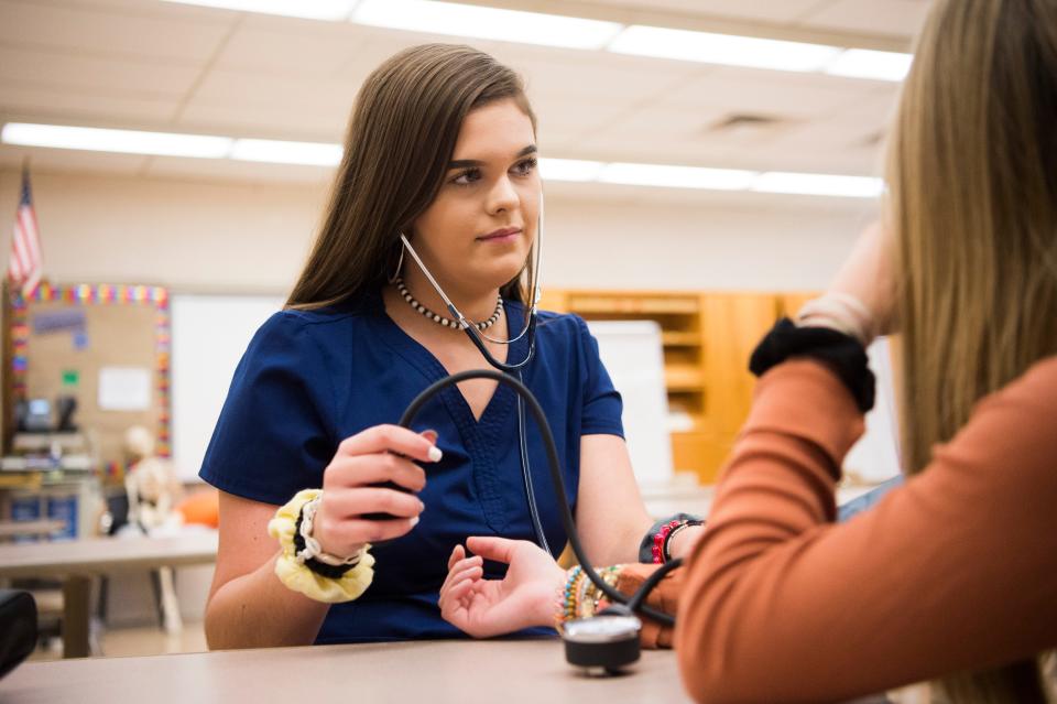 South-Doyle High School student Lacey Cardwell takes the blood pressure of one of her peers in their 2019 health sciences class. Knox County Schools is starting a pilot program that integrates career opportunities with academics.
