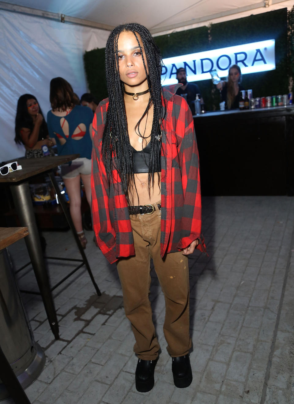 Performing with her band Lolawolf during the music portion of the festival, Kravitz hung out backstage in a flannel shirt, leather bra top, and cargo pants straight from the men’s section of J.Crew. With long braids and choker necklace, this look was straight out of the ‘90s.