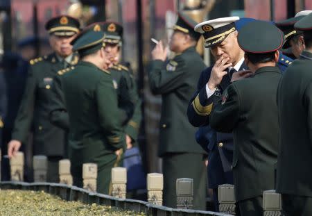 Military delegates from the Chinese People's Liberation Army (PLA) smoke at Tiananmen Square after a meeting during the annual session of China's parliament, the National People's Congress (NPC), in Beijing, China March 4, 2017. REUTERS/Jason Lee