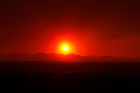 FILE PHOTO: Smoke from the Wallow Wildfire billows over the White Mountains as the sun sets in Springerville, Arizona, U.S., June 8, 2011. REUTERS/Joshua Lott/File Photo