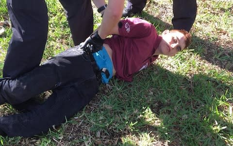 Suspect Nikolas Cruz being apprehended by police in an image posted on Twitter by ESPN's Josh Cohen - Credit: Josh Cohen