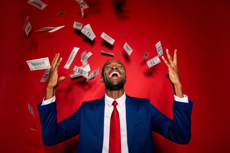 Person standing under a rain of cash. 