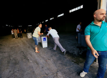 Iraqi men carry ballot boxes after a fire at a storage site in Baghdad, housing the boxes from Iraq's May parliamentary election, Iraq June 10, 2018. REUTERS/Thaier Al-Sudani