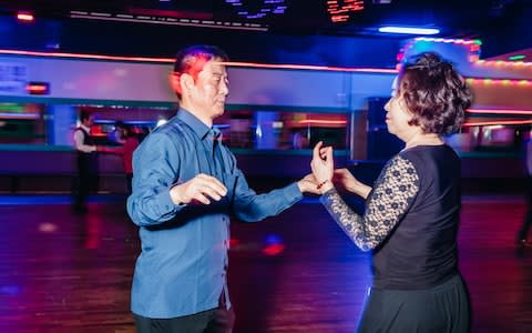 Kim Jeong-soon, 68, right, dances with a partner at Mia Cola-theque, a senior discotheque in northern Seoul, South Korea - Credit: Jun Michael Park&nbsp;