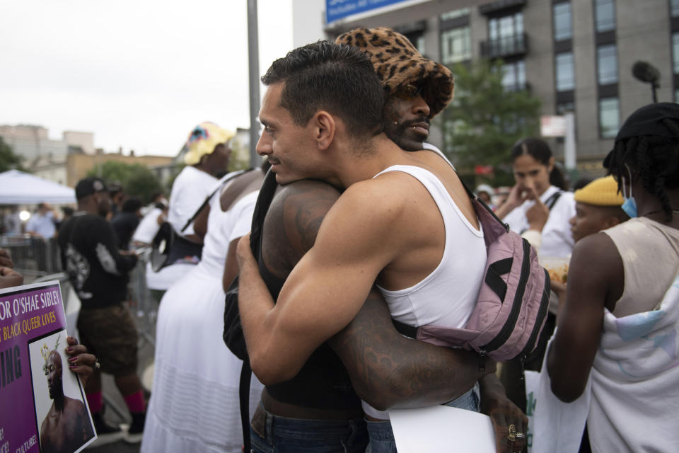 CORRECTS SECOND SENTENCE - Two people hug in front of a gas station during a vigil to memorialize O'Shae Sibley on Friday, Aug. 4, 2023, in the Brooklyn borough of New York. Sibley, a gay man, was fatally stabbed at the gas station after a confrontation between a group of friends dancing to a Beyoncé song and several young men who taunted them. (AP Photo/Tracie Van Auken)