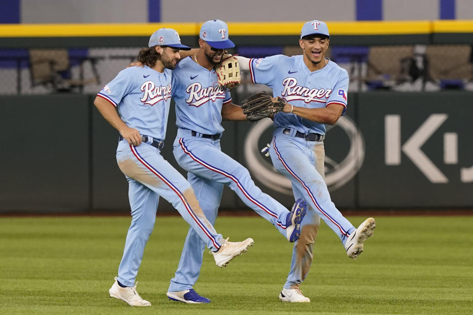 Texas Rangers out fielders Josh Smith, left, Leody Taveras, center, and Bubba Thompson dance together after the final out of the baseball game against the Toronto Blue Jays in Arlington, Texas, Sunday, Sept. 11, 2022. The Rangers won 4-1. (AP Photo/LM Otero)