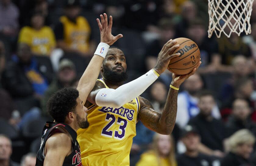 Los Angeles Lakers forward LeBron James shoots next to Portland Trail Blazers guard Skylar Mays.