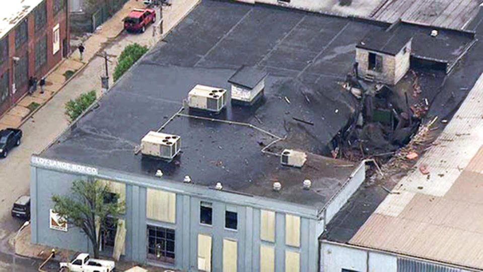This Monday, April 3, 2017 photo from video provided by KMOV shows damage to the roof of a box company in St. Louis after a boiler exploded and flew before crashing through the roof of a nearby laundry business. Authorities said several people were killed as a result of the explosion. (KMOV via AP)