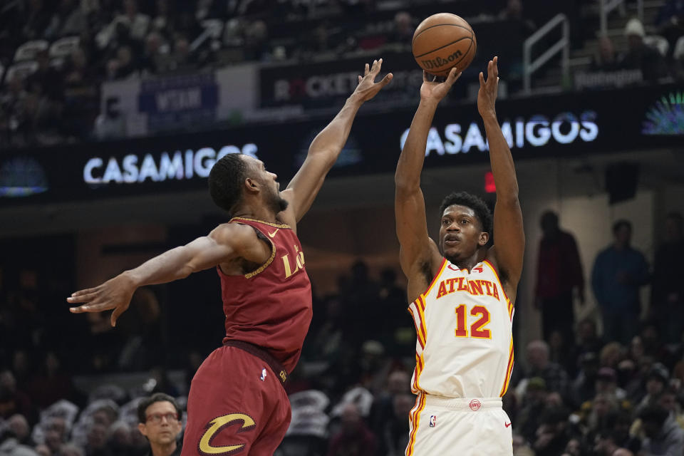 Atlanta Hawks forward De'Andre Hunter (12) shoots over Cleveland Cavaliers forward Evan Mobley, left, in the first half of an In-Season Tournament NBA basketball game, Tuesday, Nov. 28, 2023, in Cleveland. (AP Photo/Sue Ogrocki)