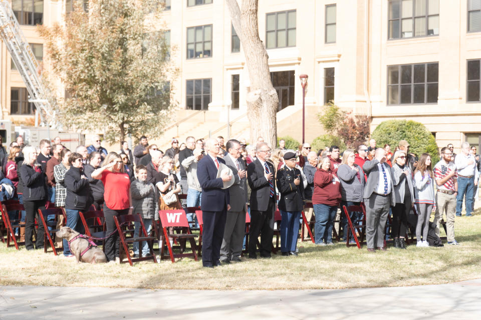 Members of the audience stand for the National Anthem at a community veterans ceremony Friday at West Texas A&M University in Canyon.