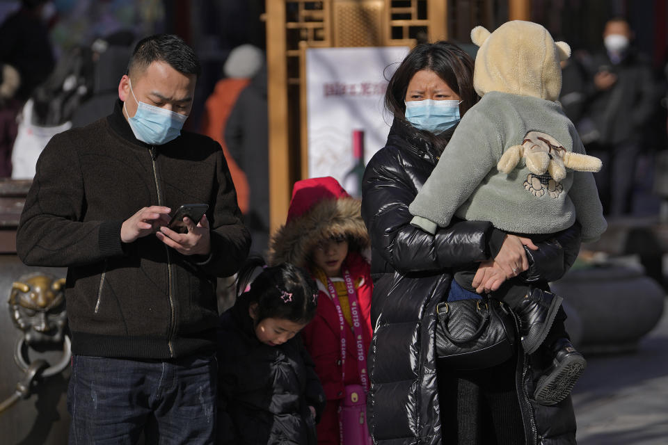 A family visit the Qianmen pedestrian shopping street, a popular tourist spot in Beijing, Tuesday, Jan. 17, 2023. China has announced its first population decline in decades as what has been the world's most populous nation ages and its birthrate plunges. (AP Photo/Andy Wong)