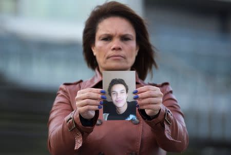 Ozana Rodrigues, the mother of Brian De Mulder, who left for Syria after being indoctrinated by Islamist group Sharia4Belgium, poses with a photo of her son outside the Antwerp courthouse, where the trial of the group is currently taking place, January 29, 2015. REUTERS/Yves Herman