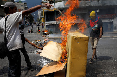 Demonstrators light a fire barricade at a protest against the government of Venezuelan President Nicolas Maduro in Caracas, Venezuela March 31, 2019. REUTERS/Carlos Garcia Rawlins