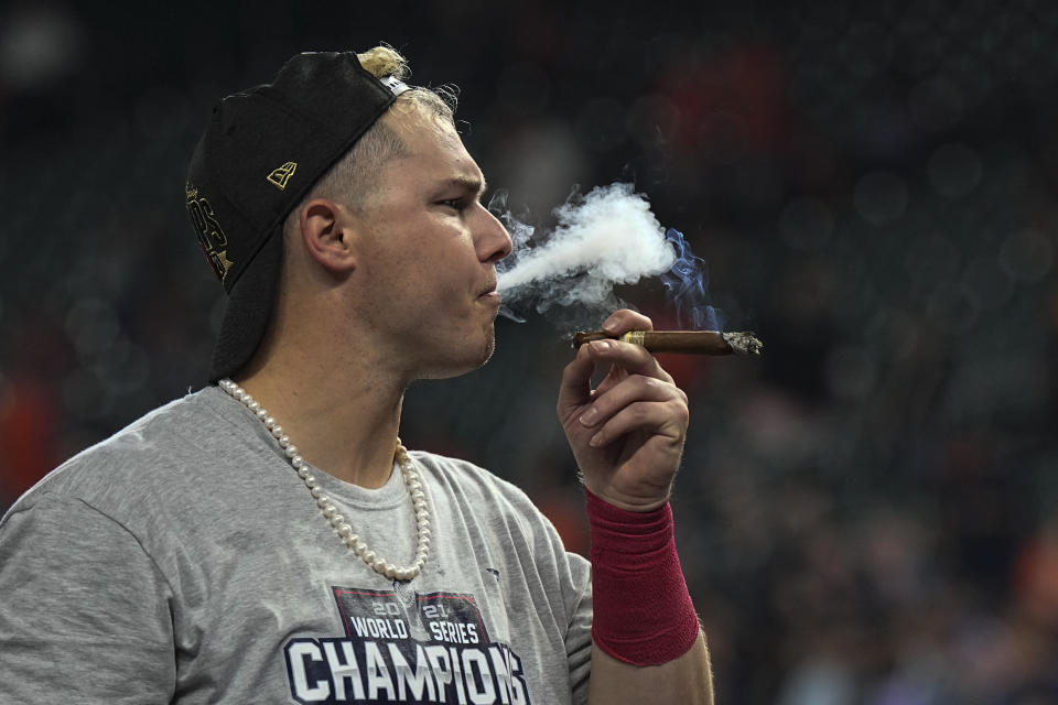 Atlanta Braves right fielder Joc Pederson celebrates with a cigar after winning baseball's World Series in Game 6 against the Houston Astros Tuesday, Nov. 2, 2021, in Houston. The Braves won 7-0. (AP Photo/David J. Phillip)