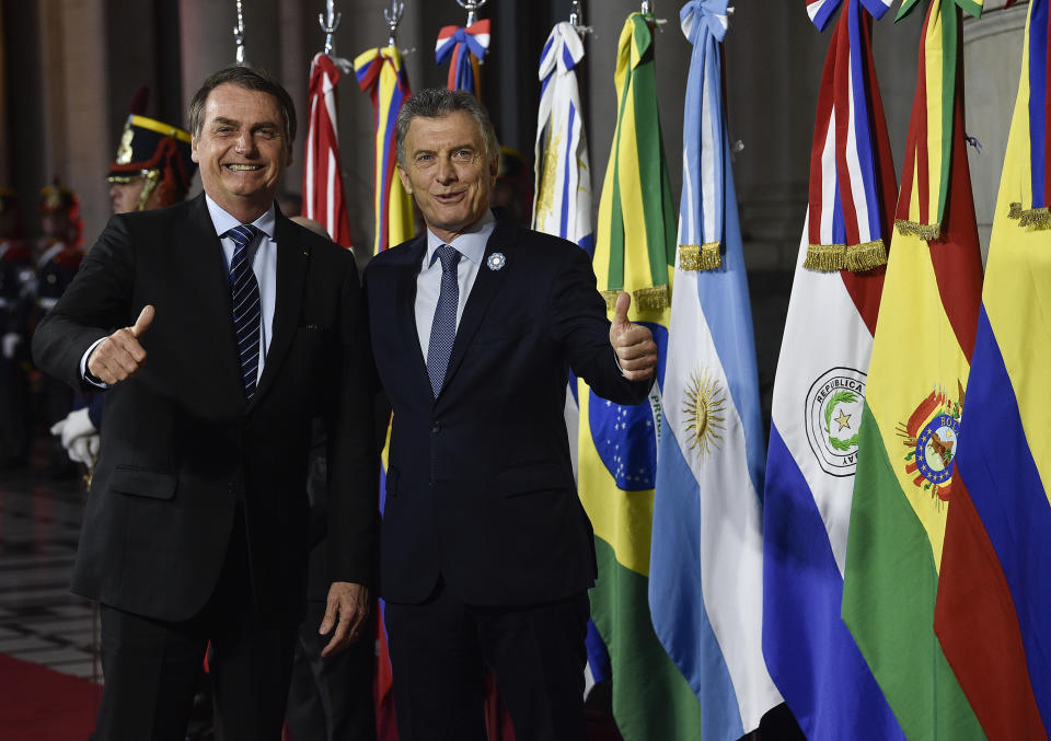 Argentina's President Mauricio Macri, right, gives a thumbs up to photographers with Brazil's President Jair Bolsonaro during a photo opportunity at the Mercosur Summit in Santa Fe, Argentina, Wednesday, July 17, 2019. The South American trading bloc that includes founding members Brazil, Argentina, Paraguay, and Uruguay, is one of the world's largest. (AP Photo/Gustavo Garello)