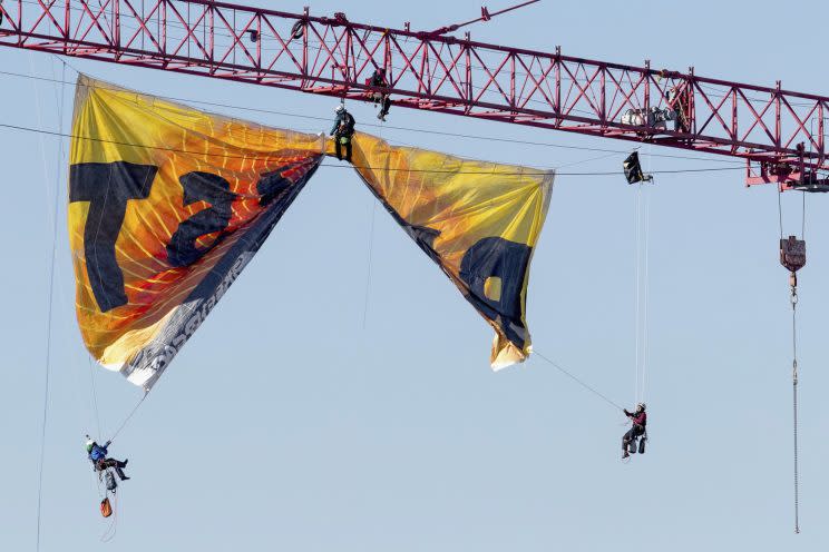 Greenpeace protesters unfurl a banner from a crane near the White House