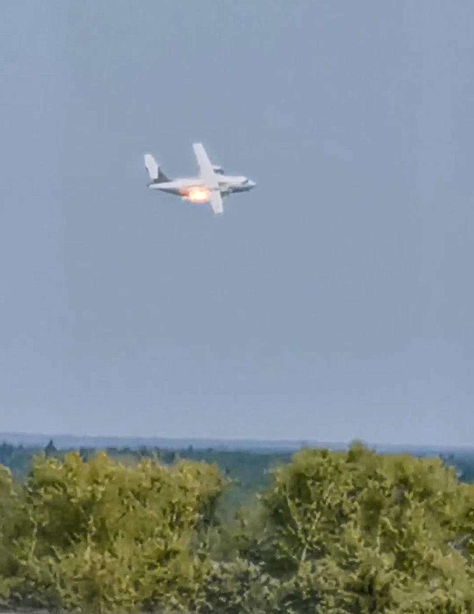 In this handout photo taken from video provided by Dmitry Ovchinnikov, The new light military transport burning plane Il-112V flies near Kubinka airfield about 45 kilometers (28 miles) west of Moscow, Russia, Tuesday, Aug. 17, 2021. A prototype military transport plane crashed while performing a test flight outside Moscow on Tuesday, Russian news agencies reported, citing Russia's United Aircraft Corporation. The new light military transport plane, Il-112V, crashed in a forested area as it was coming in for a landing at the Kubinka airfield about 45 kilometers (28 miles) west of Moscow, spokespeople of the corporation told the Tass news agency. (Dmitry Ovchinnikov via AP)