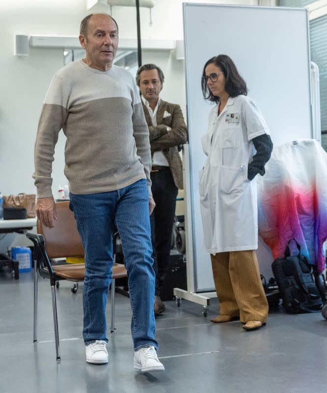 Marc Gauthier, de 63 años, el primer paciente con una neuroprótesis, programada para estimular su médula espinal para corregir los trastornos de la marcha causados por la enfermedad de Parkinson, se planta frente a Gregoire Courtine, profesor de neurociencia en el Instituto Federal Suizo de Tecnología (EPFL) y Jocelyne. Bloch, neurocirujano y profesor del Hospital Universitario de Lausana (CHUV), durante una presentación ante los medios en el laboratorio NeuroRestore del CHUV en Lausana, Suiza