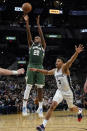 Milwaukee Bucks' Khris Middleton (22) shoots over San Antonio Spurs' Keldon Johnson (3) during the second half of an NBA basketball in San Antonio, Texas, Saturday, Oct. 23, 2021. (AP Photo/Chuck Burton)