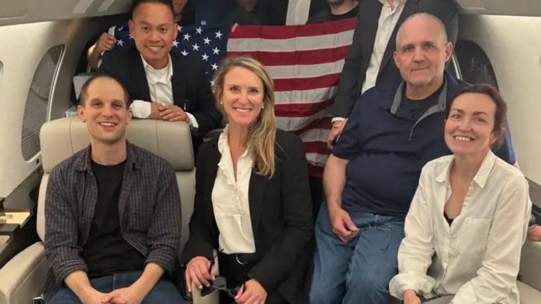 Los prisioneros estadounidenses en el avión tras ser liberados: Evan Gershkovich (a la izquierda), Paul Whelan (camiseta azul) y Alsu Kurmasheva (con blusa blanca a la derecha).