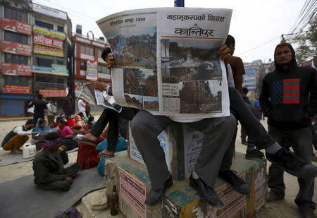 People read newspapers on the street a day after an earthquake in Kathmandu, Nepal April 26, 2015. REUTERS/Navesh Chitrakar