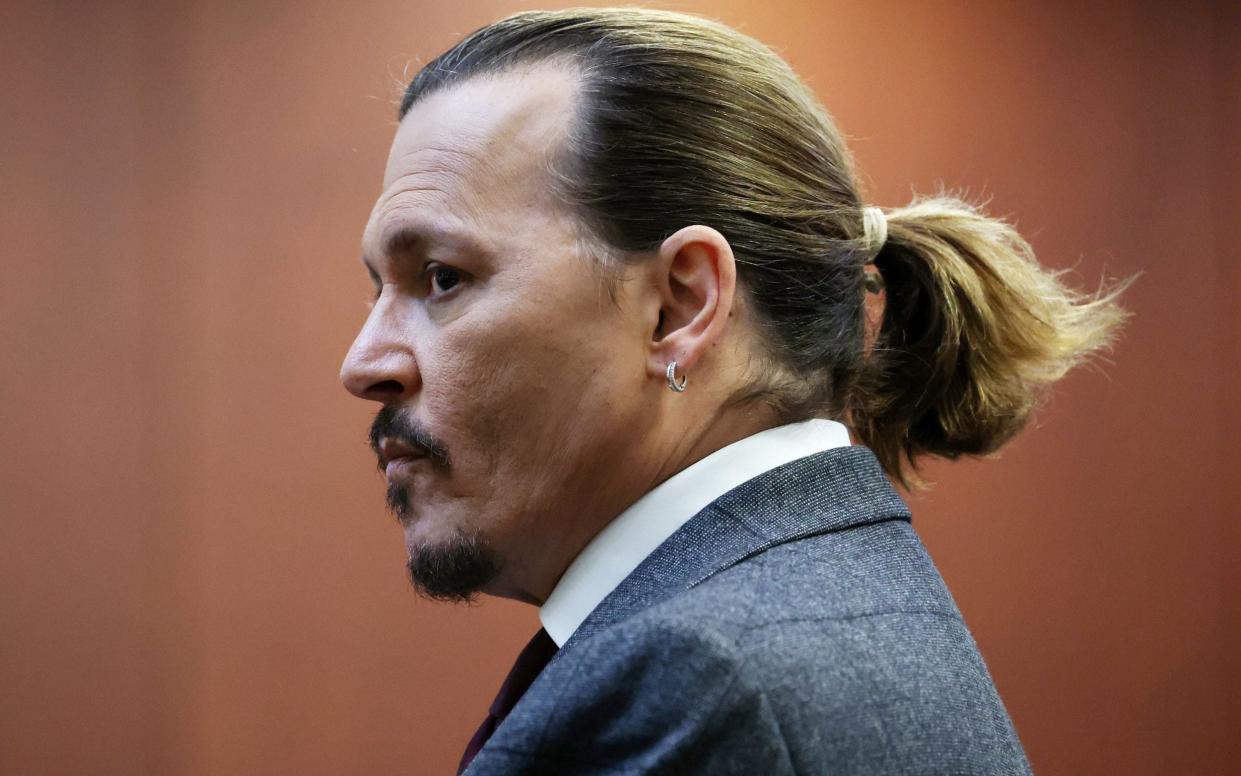 Johnny Depp, wearing a grey suit with his hair pulled back in a short pony tail, watches the jury return to court following a break in the trial - MICHAEL REYNOLDS/EPA-EFE/Shutterstock