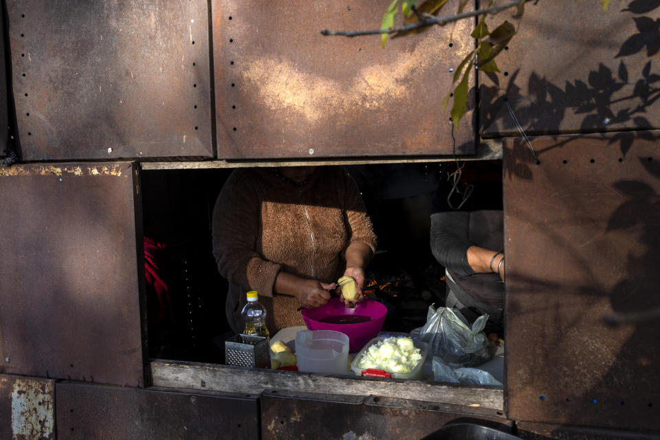 A member of the Frente de Organizaciones en Lucha, FOL, social organization, peels potatoes while preparing lunch in their soup kitchen in the "El Peligro" neighborhood, south of Buenos Aires, Argentina, Friday, May 20, 2022. The FOL runs the soup kitchen along with a daycare center, vegetable garden, library and a study center for high school students in the impoverished neighborhood. (AP Photo/Rodrigo Abd)