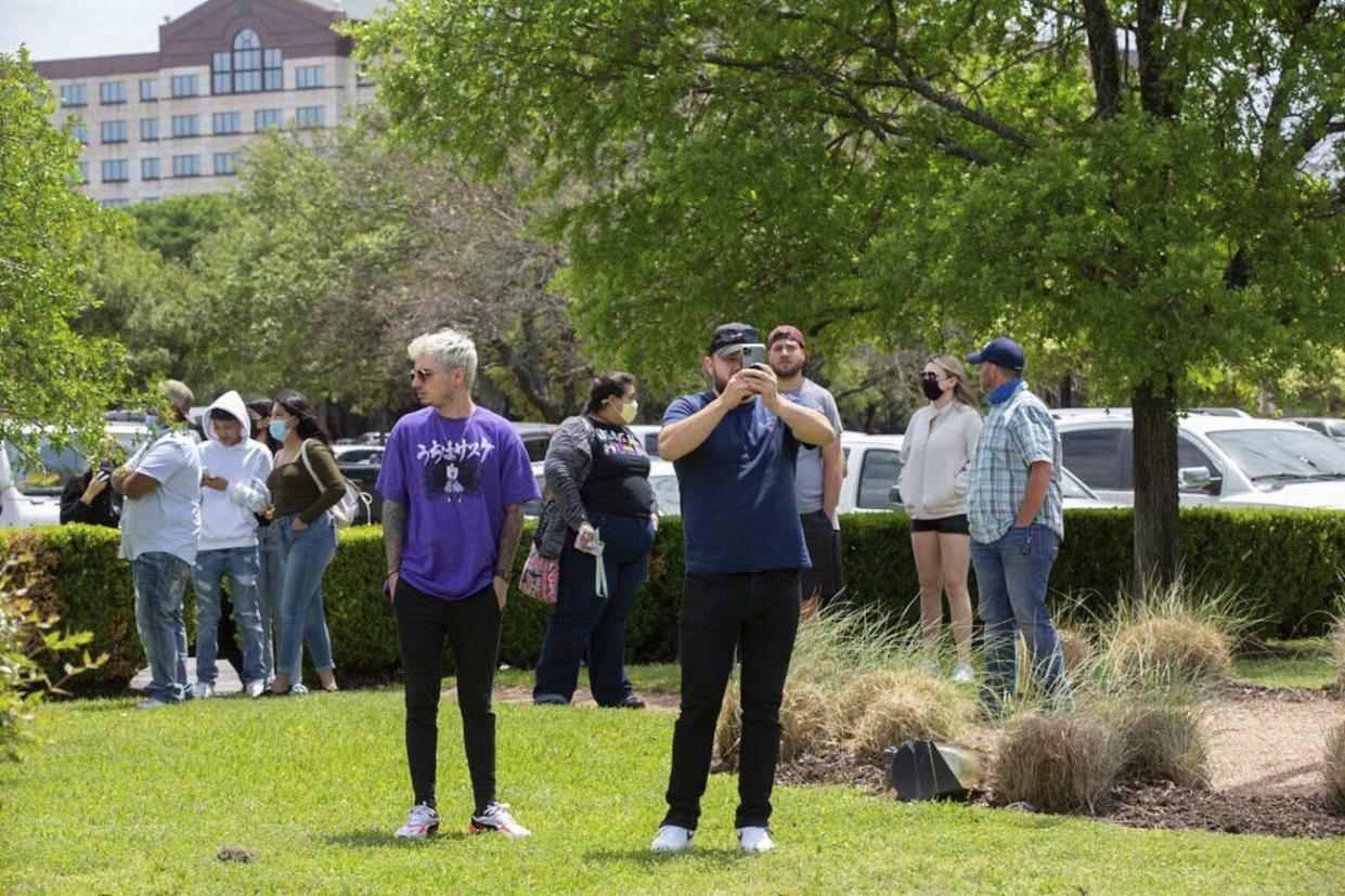 People watch as police, SWAT and medical personnel respond to a fatal shooting in the Arboretum area of northwest Austin on Sunday, April 18, 2021.